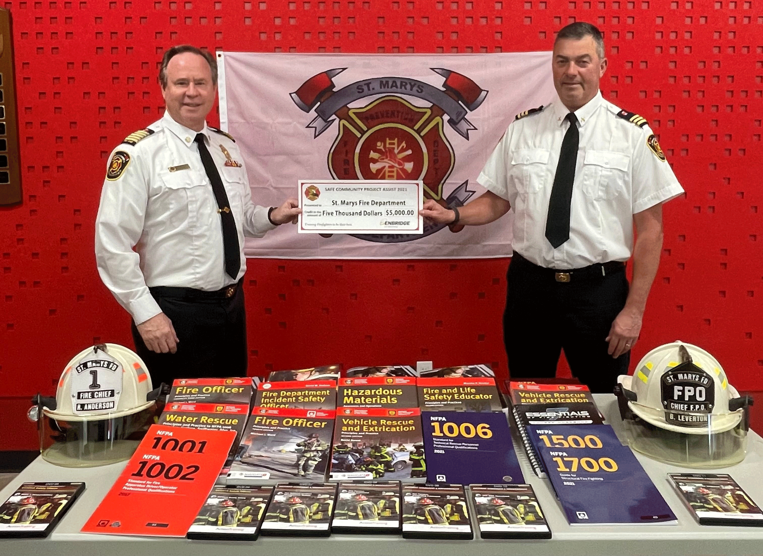 from Left) St. Marys Fire Chief Richard “Andy” Anderson and Chief Fire Prevention Officer Brian Leverton display firefighter training materials purchased with donation.