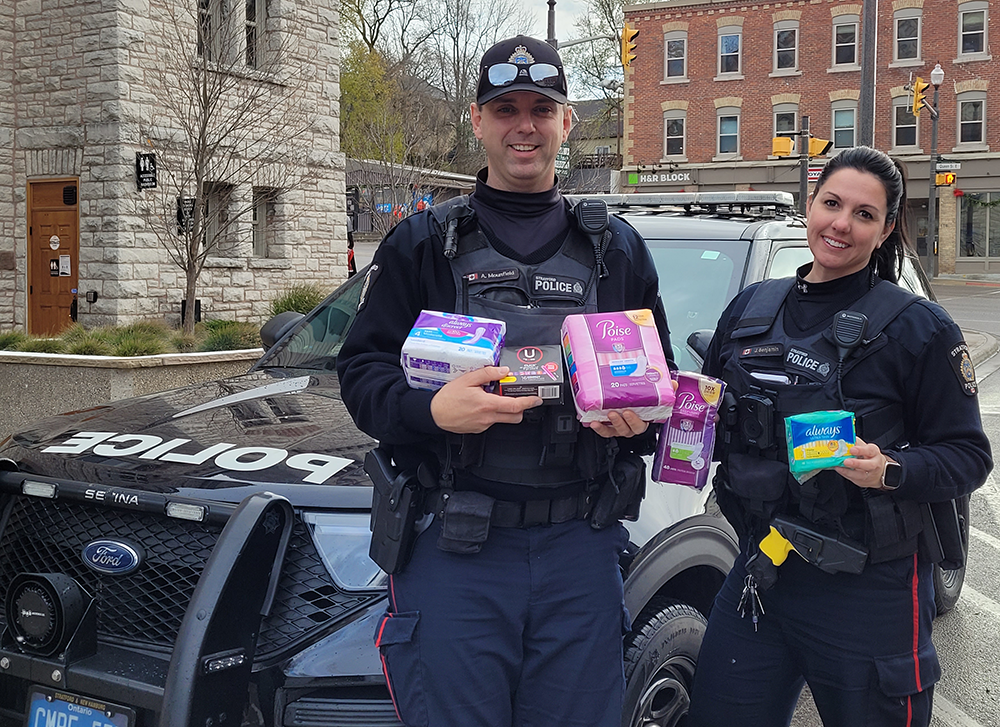 Police standing in front of car with feminine hygiene products