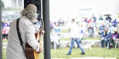 Musician playing guitar for a crowd